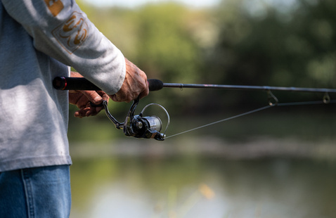 Close up of a person holding a fishing rod
