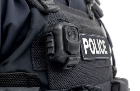 Body camera on a person wearing a police uniform.