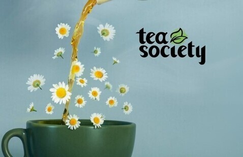 A stream of tea flows into a mug. Floating in the air around the mug are small, white daisies. The text next to the mug reads "Tea Society."