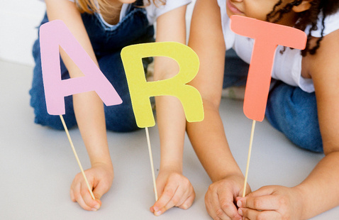 Children holding the letters "A, R, T."