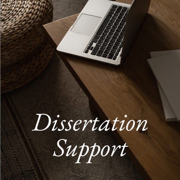 Dissertation support group image of dark wood table with laptop and pouf