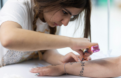 Someone using henna to apply a design