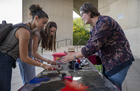 People at table outside the fine arts center