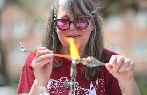 A person blowing a glass tube
