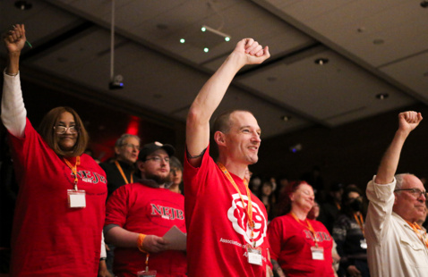 People in red t-shirts raising their fists