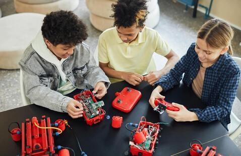 Teens work on a robot together