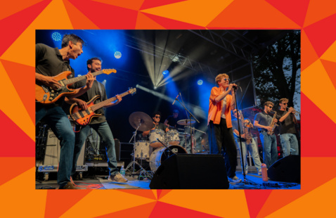 ArThe Yard Bops mid-performance onstage in jeans and t-shirts, in a red geometric frame