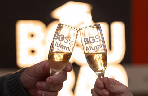 Two champagne glasses that read BGSU Alumni with marquis letters in the back