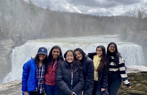 students standing in front of a waterfall.