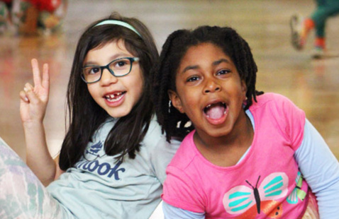 Two campers in KidSpirit gym smiling