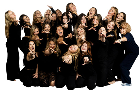 A group of 21 Dance Theatre members in black dancewear pose with arms outstretched