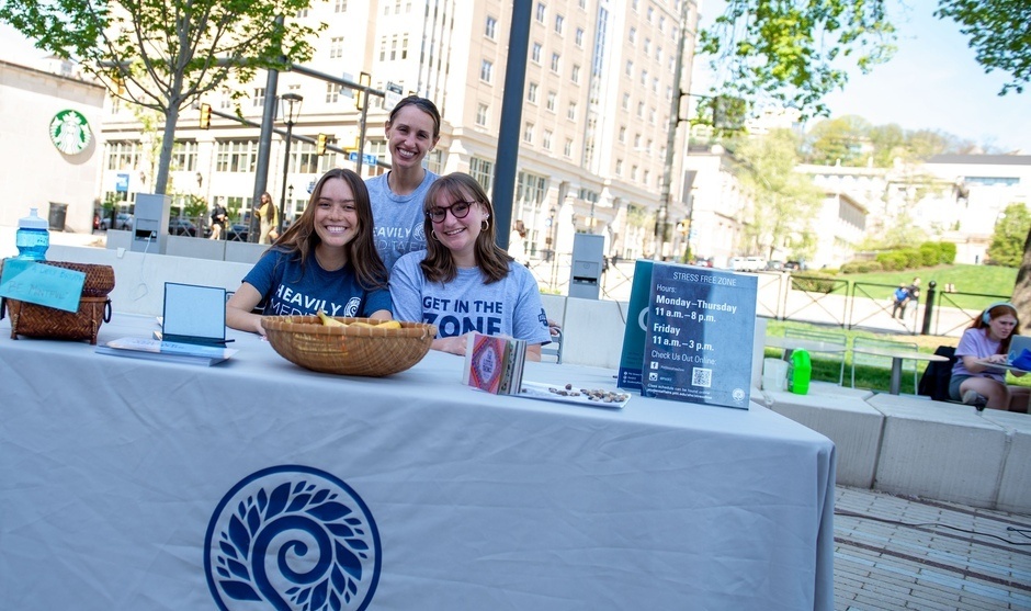 Three women sitting in a table labeled "Stress Free Zone"