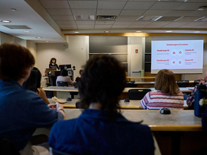Student presents at Senior Symposium, audience in foreground