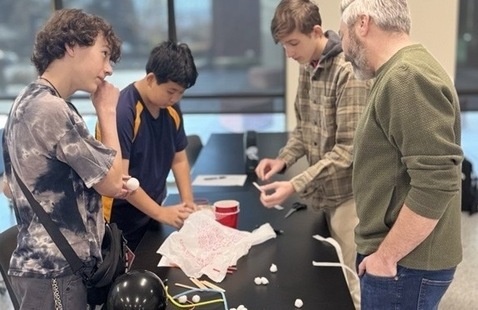 Students working on a hands-on activity with the professor