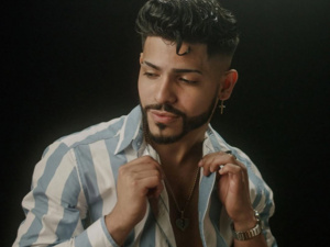 Headshot of Roshay, the facilitator, with a blue and white stripe button up.