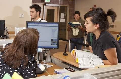 Student looks at a computer screen shown by Registration staff member