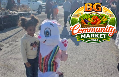 a child and a mascot together with the community market bg logo