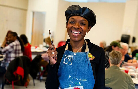 Person wearing blue smock smiling
