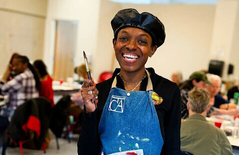 Person wearing blue smock smiling