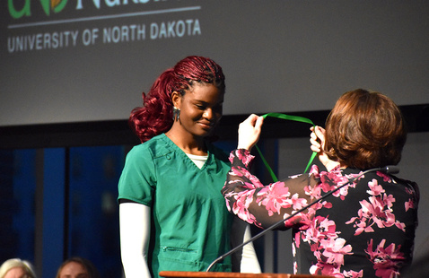 A student receives a pin