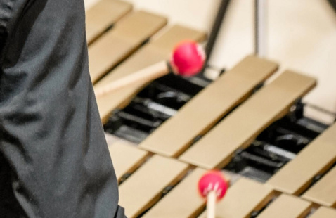 Looking over a xylophone player's shoulder as the mallets hit the keys.