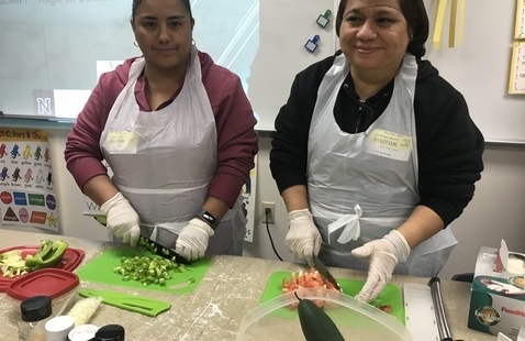 Two women preparing pasta salad 