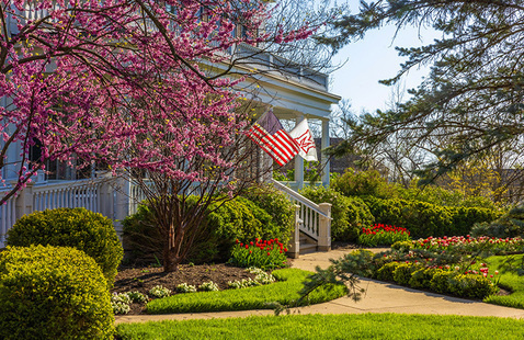 Lewis place front porch in spring with American flag and Miami flag