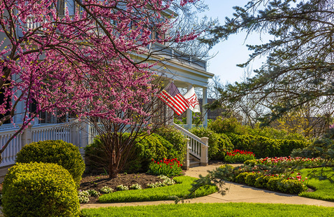 Lewis place front porch in spring with American flag and Miami flag