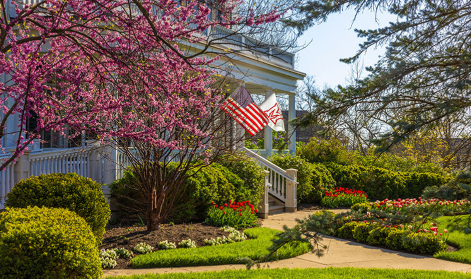 Lewis place front porch in spring with American flag and Miami flag