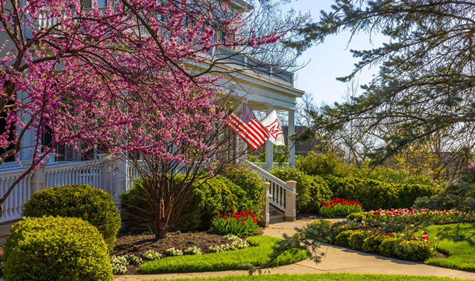 Lewis place front porch in spring with American flag and Miami flag