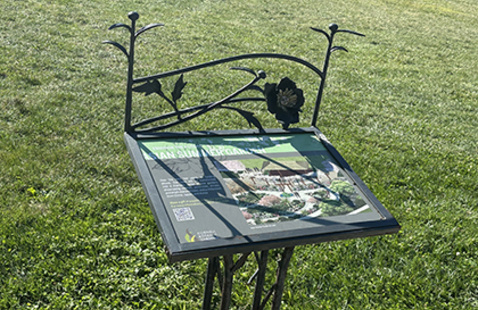 Image of metal sign with a sculptural peony flower in metal at the top.