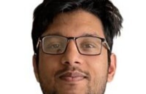 Headshot if a man with black hair and glasses.