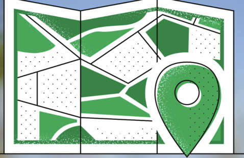 An unfolded paper map. Next to it is a green map marker.