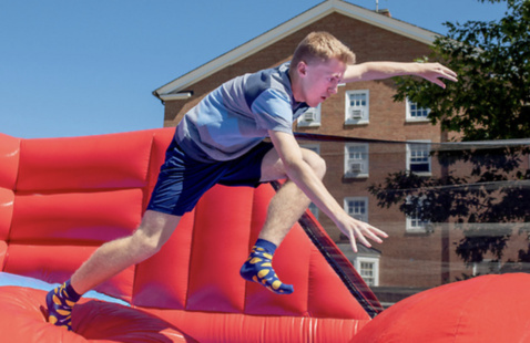 a student running on a bounce house