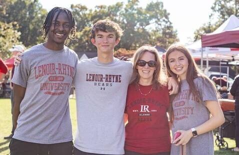 Four people pose for a photo during Homecoming