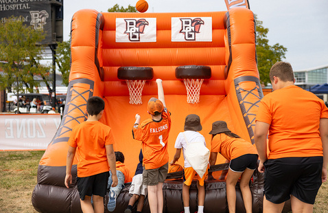 Young people shooting basketballs in inflated basketball game