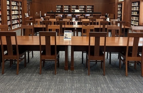 Several wooden chairs and tables in the Pratt library's reading room