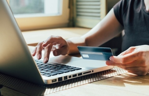 person typing credit card information onto a laptop
