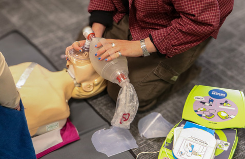 Students practicing CPR on a CPR mannequin.