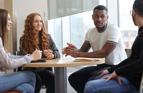 a group of students chatting at a round table