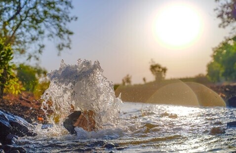 Creek water splashing around a rock.