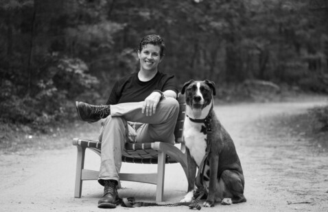 woman sitting on a chair with a dog next to her
