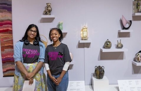 Two people standing in front of an exhibition at an art museum
