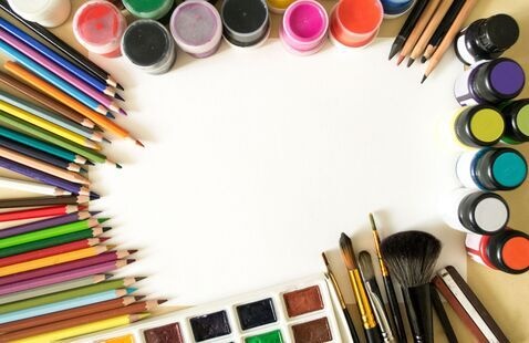 Variety of art supplies including paints, pencils, and brushes on a white background