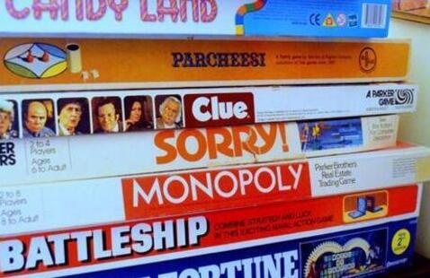 A stack of board games including Monopoly, Sorry, and Clue