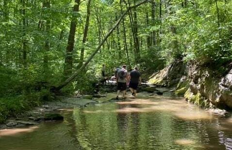 Hikers walking up creek