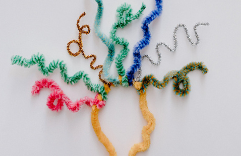 Creative arrangement of colorful pipe cleaners resembling a brain on a white background.