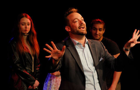 Appears to be performers on stage during an improv comedy event.