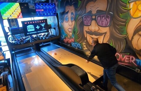 A person playing a game of duck pin bowling