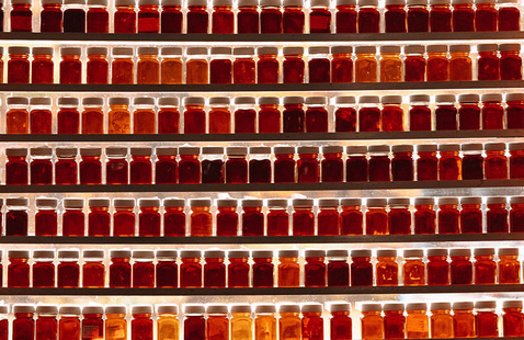 many small bottles of maple syrup stacked on shelves